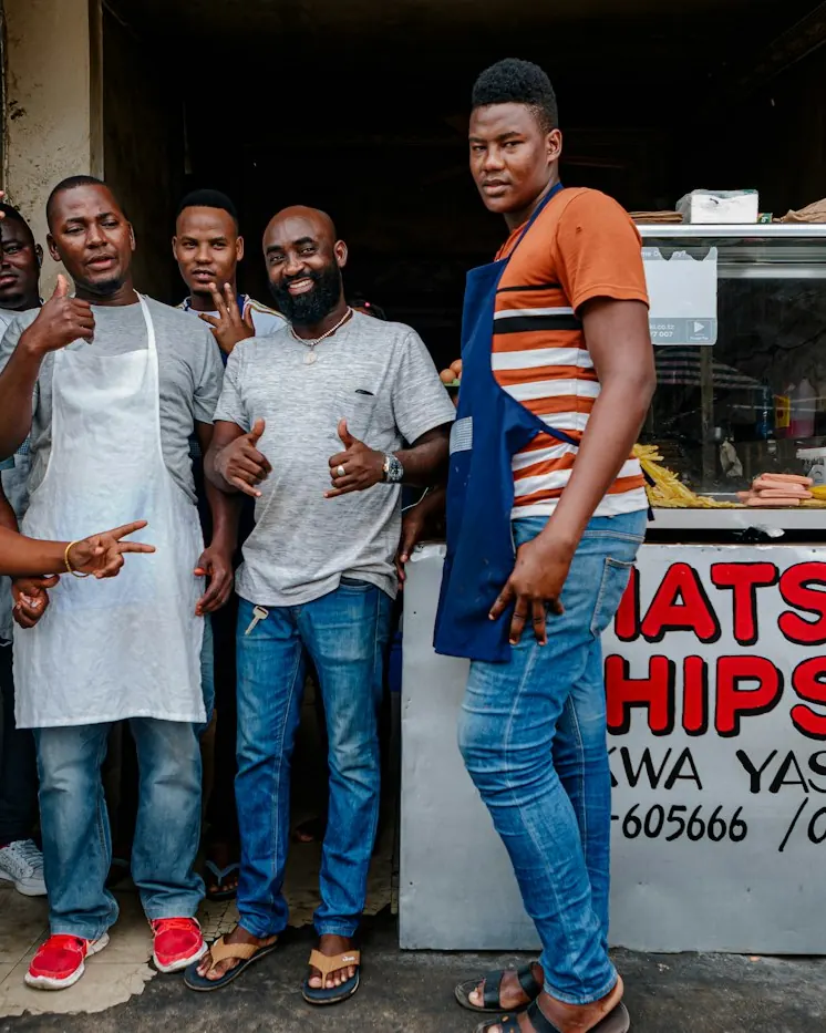 A small crew standing together in front of their shop