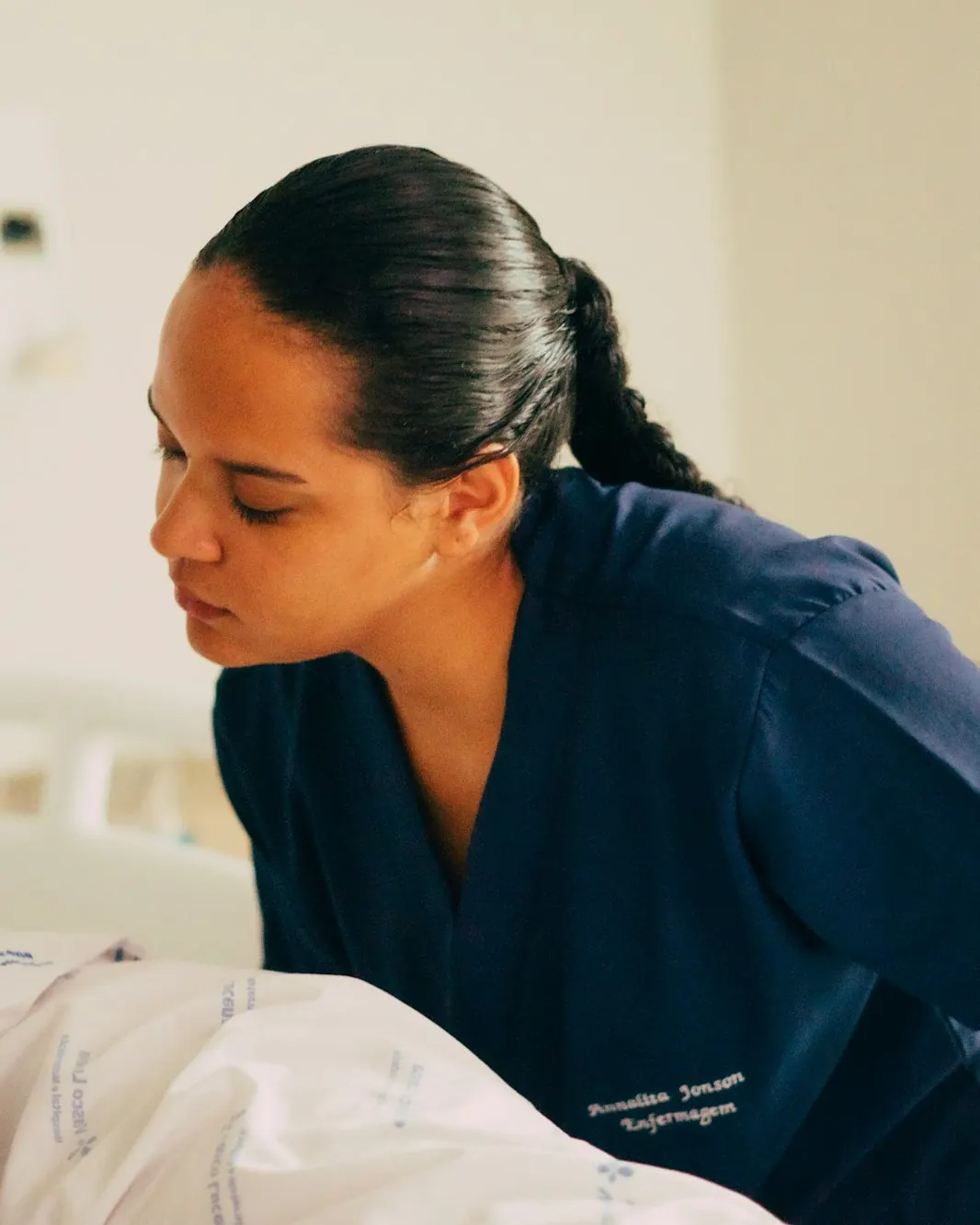 A nurse in navy scrubs caring for a patient