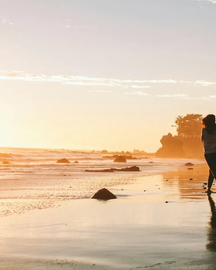 A couple dancing on the shore at sunset